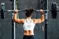 Woman lifting weights during a strength-training workout to develop muscular strength and physical fitness