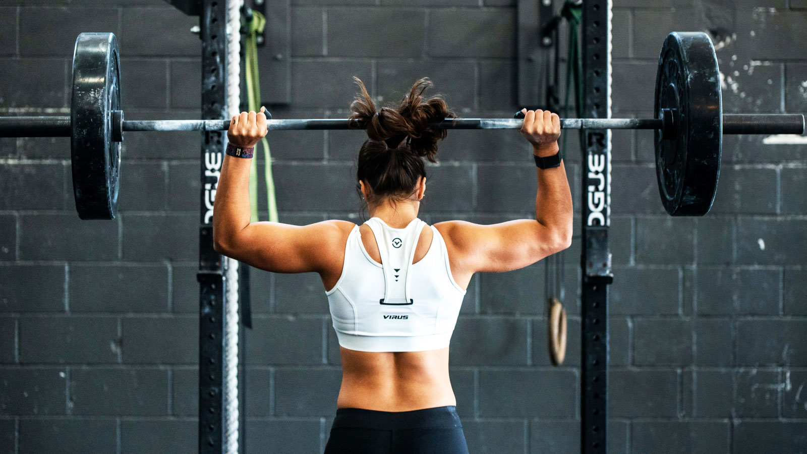 Woman lifting weights during a strength-training workout to develop muscular strength and physical fitness